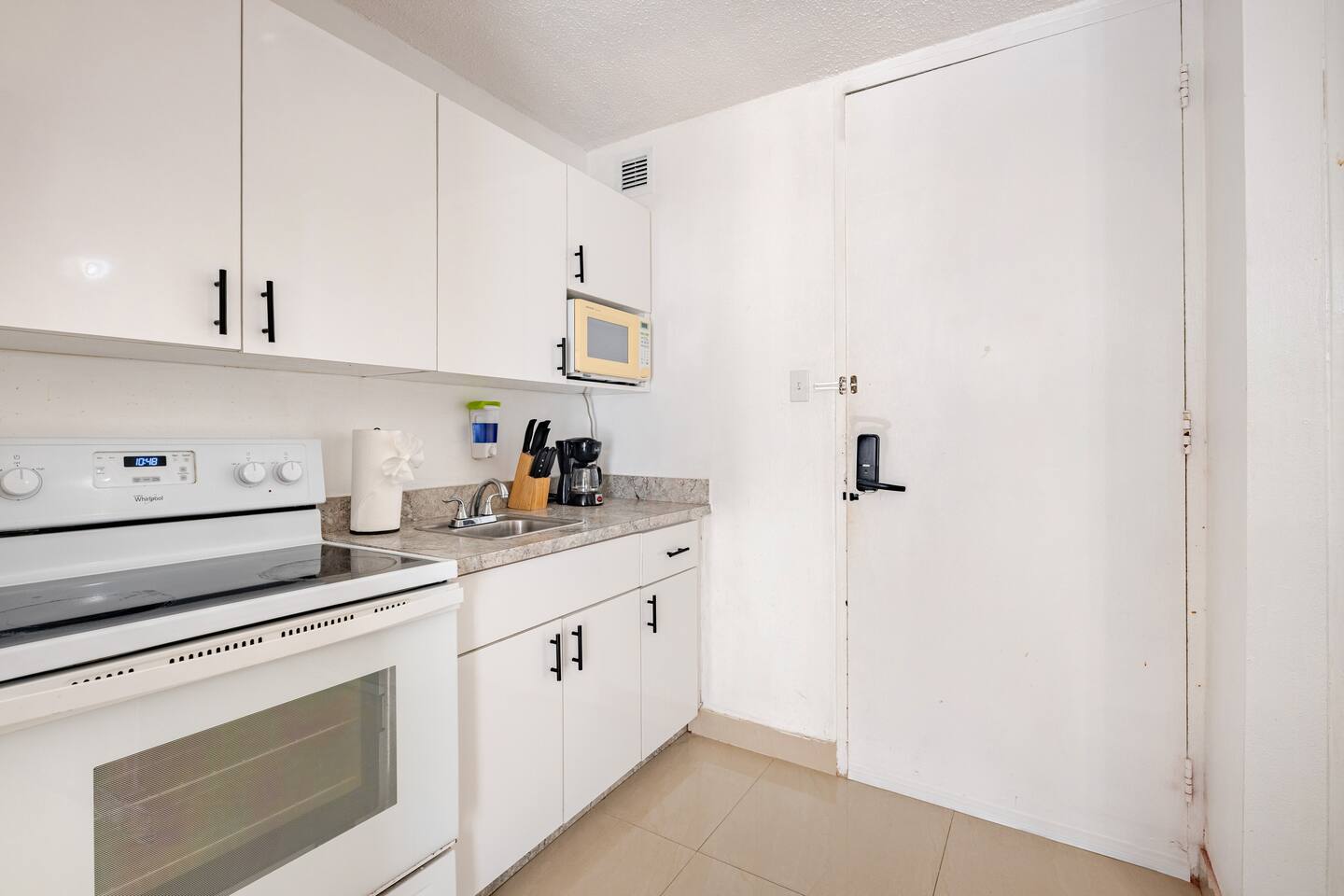 Cocina limpia y equipada con gabinetes blancos